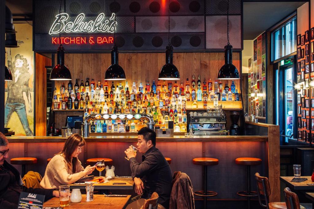 un grupo de personas sentadas en un bar en St Christopher's Inn Amsterdam - The Winston, en Ámsterdam