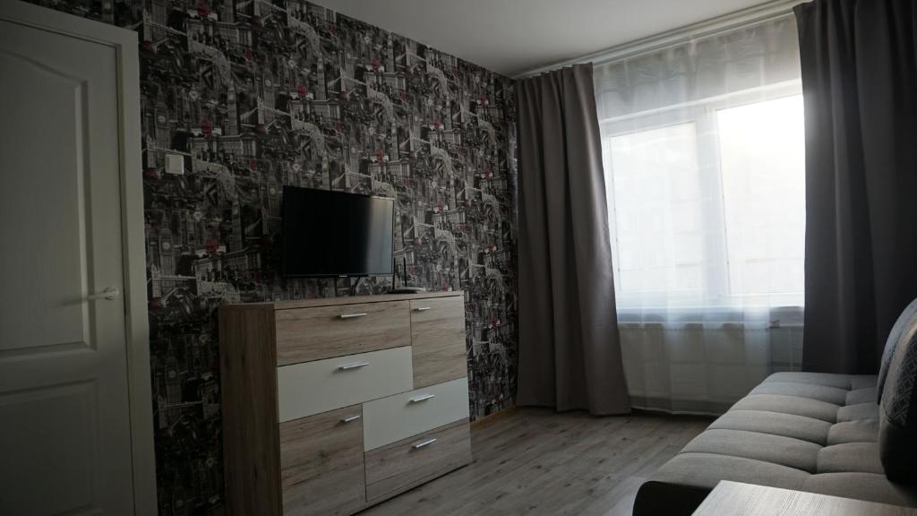 una stanza con un comò con una televisione di Sunny Ventspils 17 a Ventspils