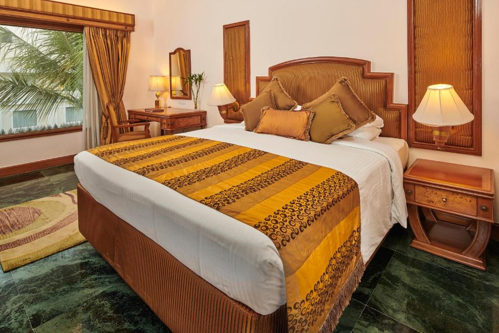 a bedroom with a large bed and a window at The Ummed Ahmedabad Airport in Ahmedabad