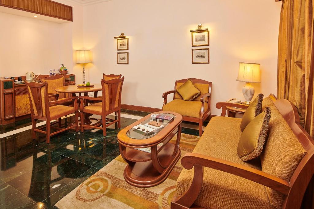 a living room with a couch and chairs and a table at The Ummed Ahmedabad Airport in Ahmedabad