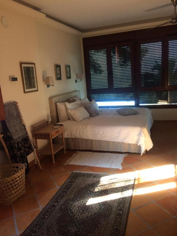 a bedroom with a bed and a table and windows at villaquinta in La Herradura