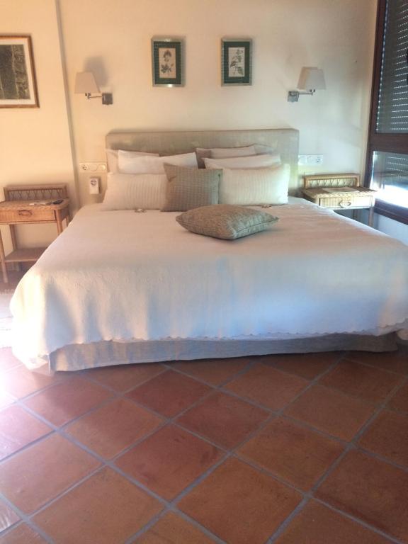 a bedroom with a large bed with white sheets and pillows at villaquinta in La Herradura
