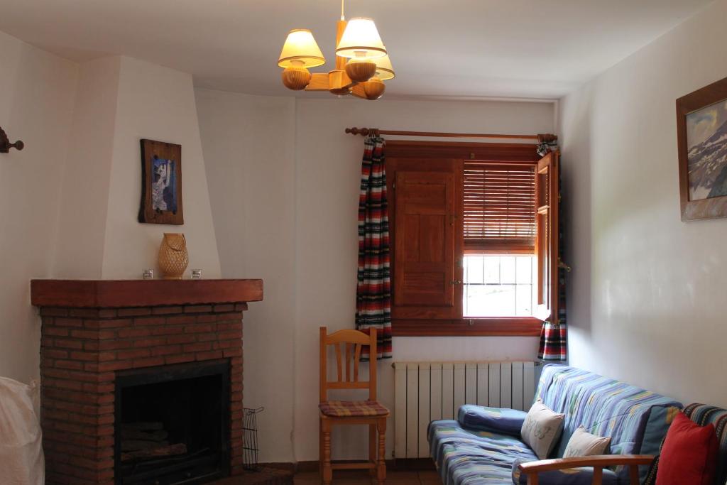 a living room with a couch and a fireplace at Apartamentos Rurales Rosendo: "El Laurel" in Capileira