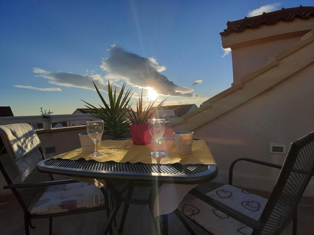 a small table on a balcony with glasses on it at Apartment Place 2 Stay in Hvar