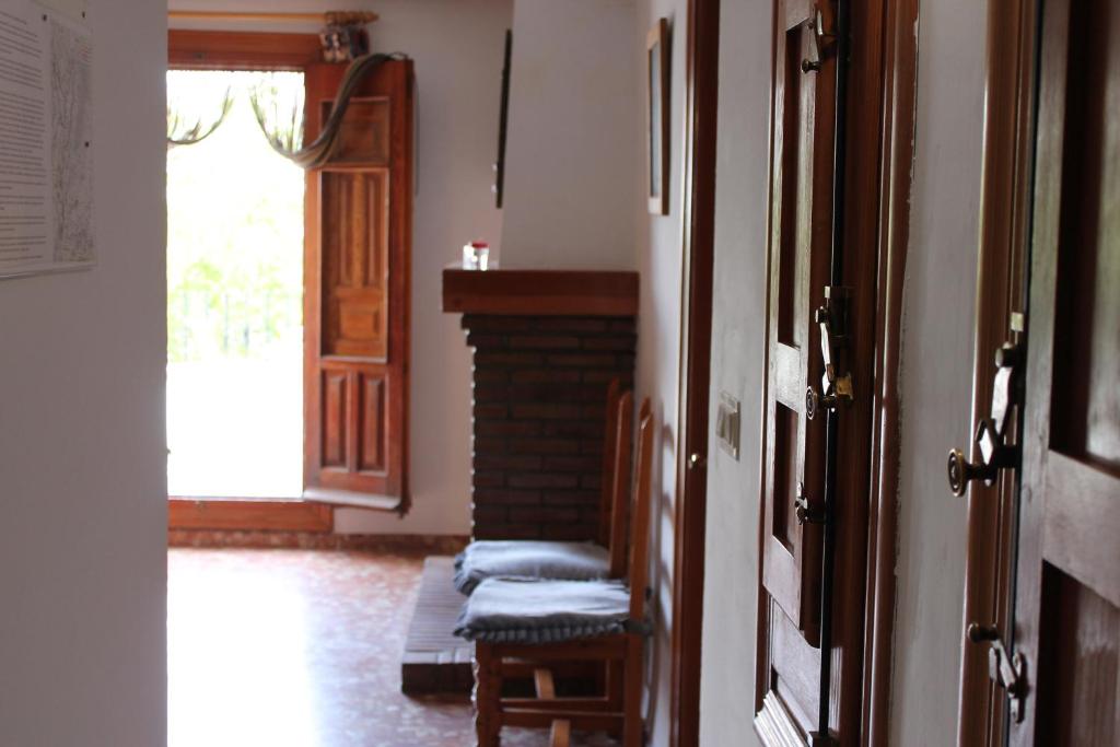 Zimmer mit einer Tür, einem Stuhl und einem Fenster in der Unterkunft Apartamentos Rurales Rosendo: "Flor de Lys" in Capileira