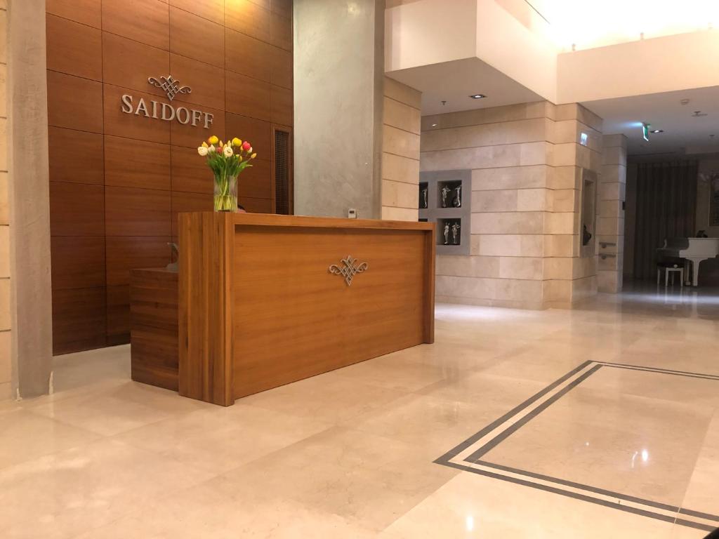 a lobby with a vase of flowers on a counter at Saidoff Luxury Residence in Jerusalem