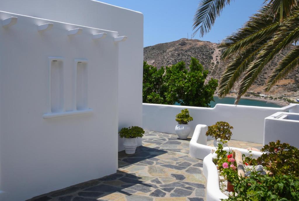a white house with palm trees and a pool at Agia Kyriaki Studios in Agia Kiriaki Beach