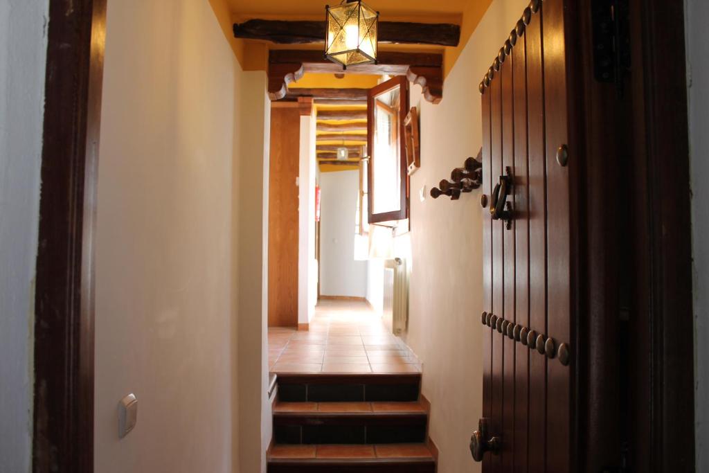 un pasillo con escaleras y una puerta con luz en Apartamentos Rurales Rosendo: "Suite Veleta" en Capileira