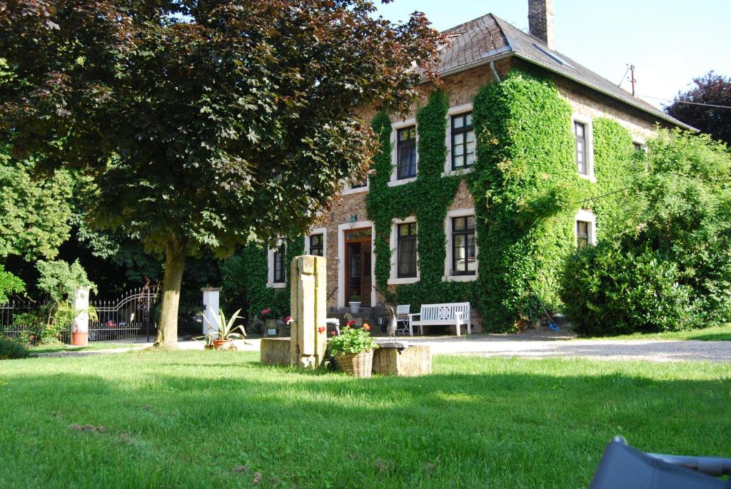 an ivycovered house with a bench in the yard at Hof Liebeneck in Osterspai