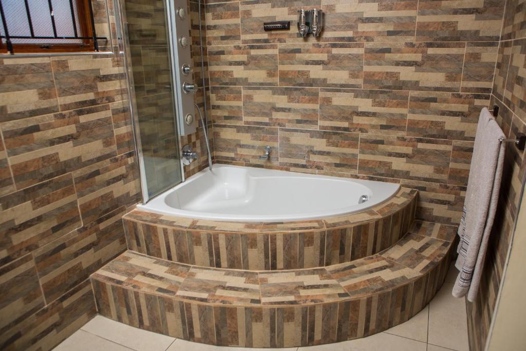 eine Badewanne im Bad mit Dusche in der Unterkunft DYNA GUEST HOUSE in Durban