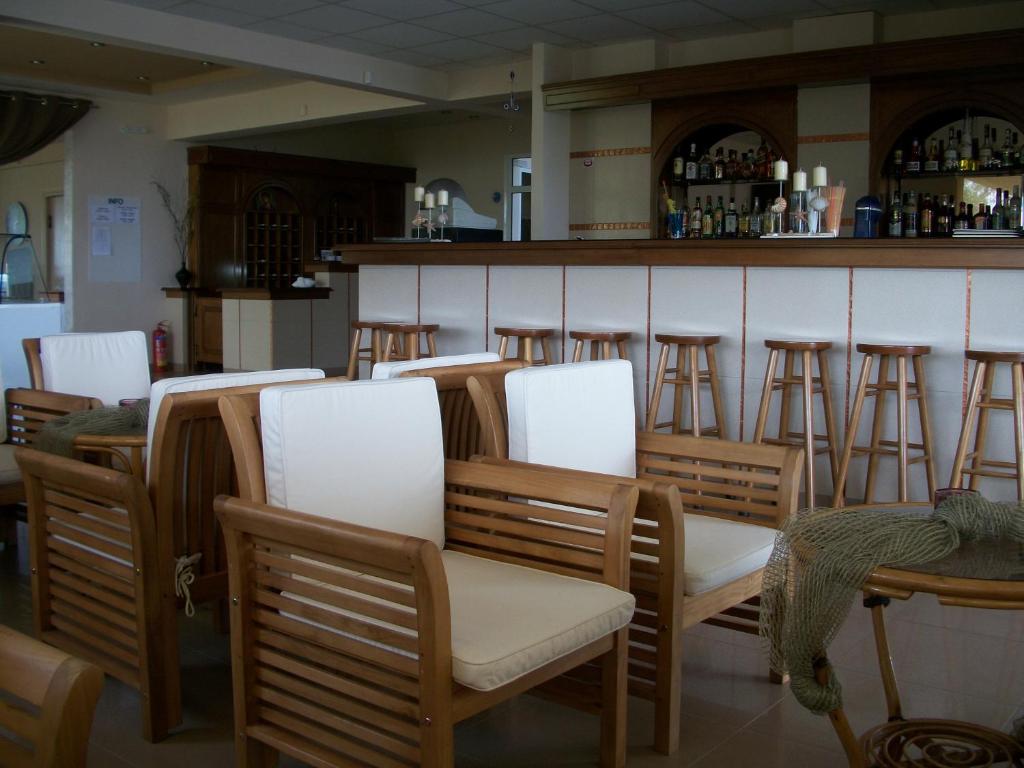 a row of chairs and a bar in a restaurant at Thea Hotel in Possidi