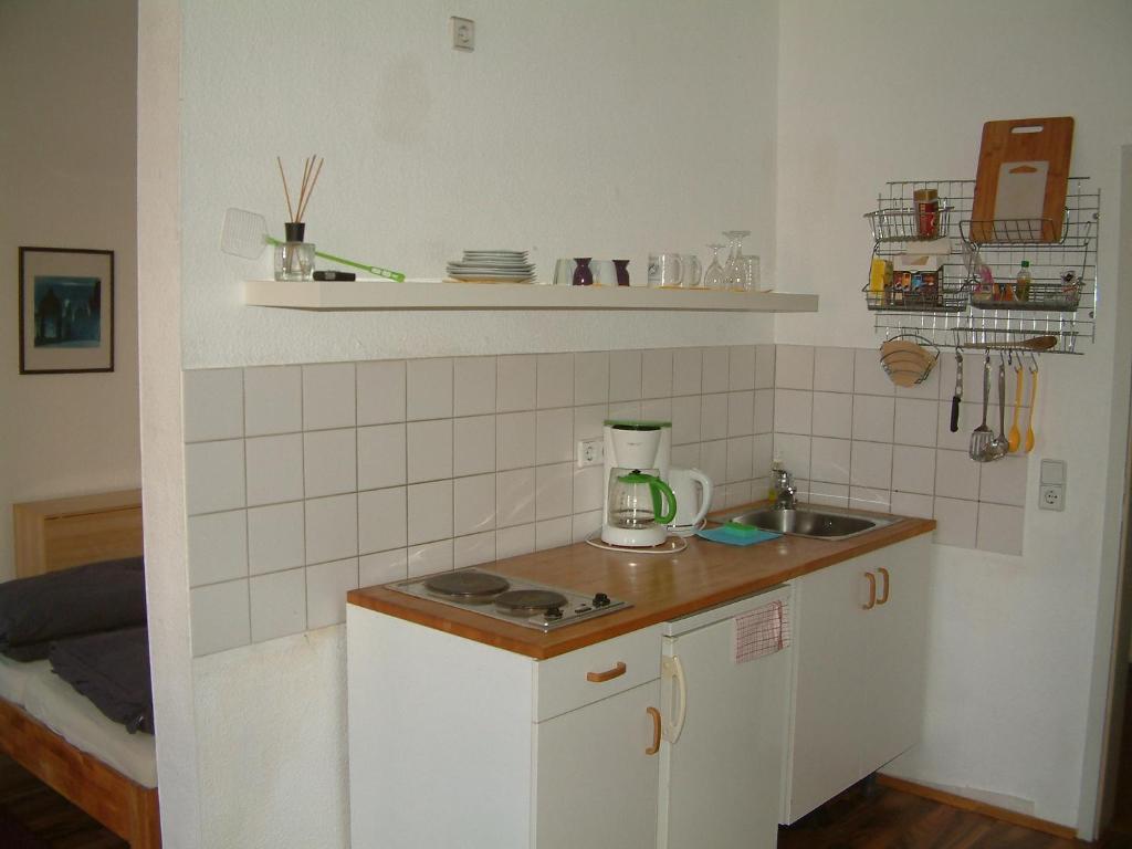 a small kitchen with a counter and a sink at Pension Olé in Dresden