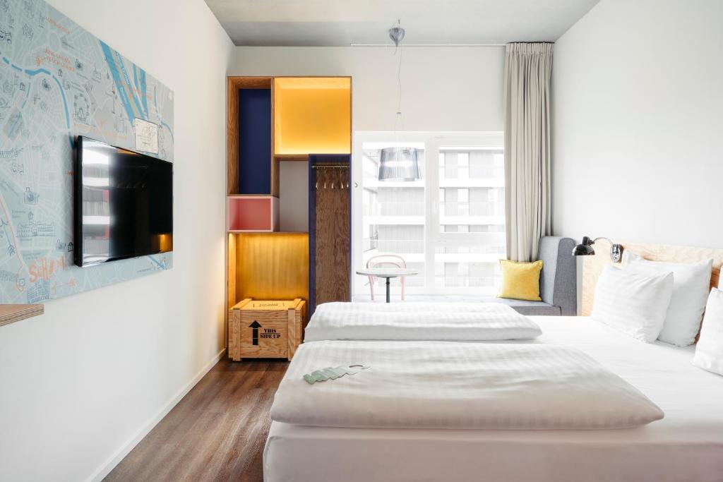 a bedroom with a bed and a television at Hotel Schani Wien in Vienna