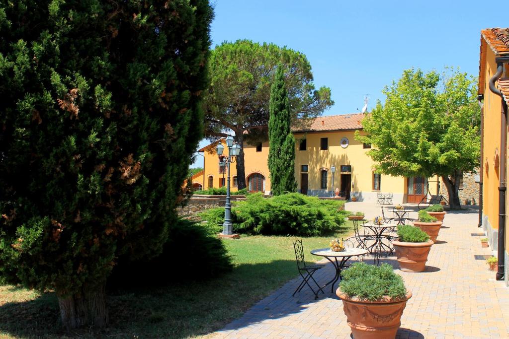 a garden with tables and chairs and a building at Il Borgo di Montereggi in Limite