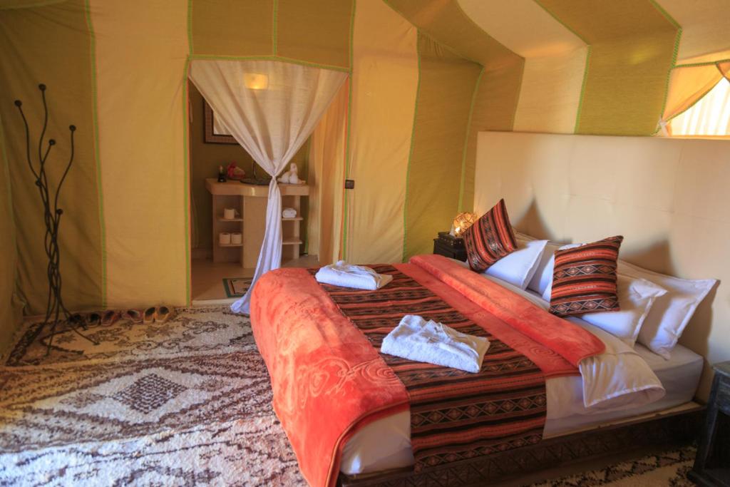 a bedroom with a large bed in a room at Sahara Desert Luxury Camp in Merzouga