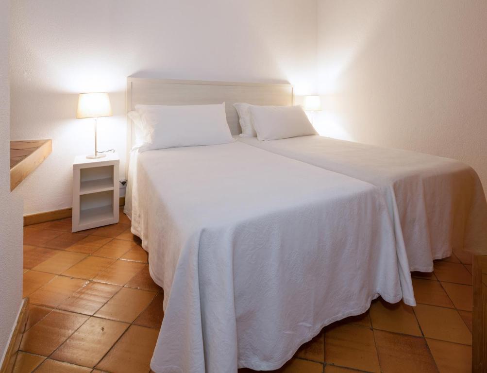a bedroom with a large white bed with two pillows at Dom Pedro Lagos in Lagos