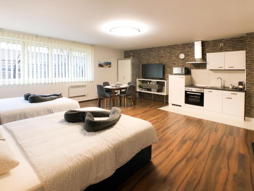 ein Zimmer mit 2 Betten, einer Küche und einem Esszimmer in der Unterkunft VIPs Apartments in Wien