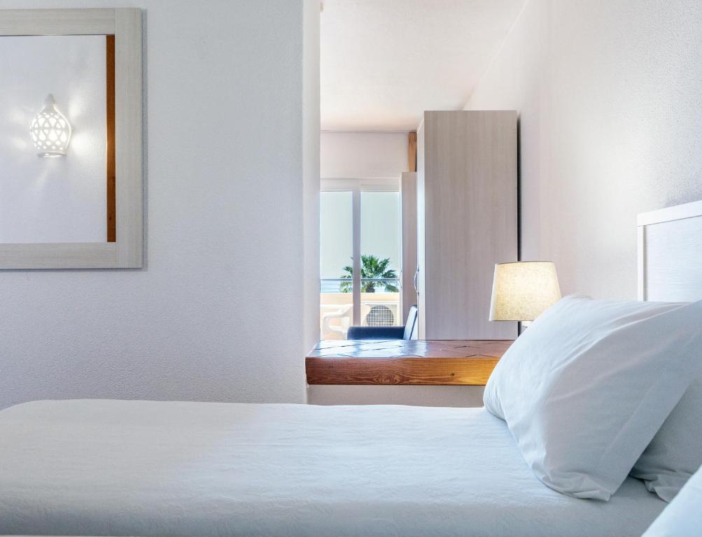a bedroom with a bed and a view of the ocean at Dom Pedro Lagos in Lagos