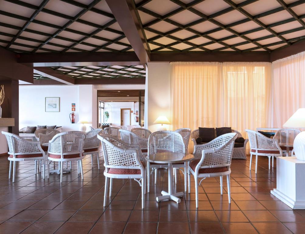a room with wicker chairs and tables and a couch at Dom Pedro Lagos in Lagos