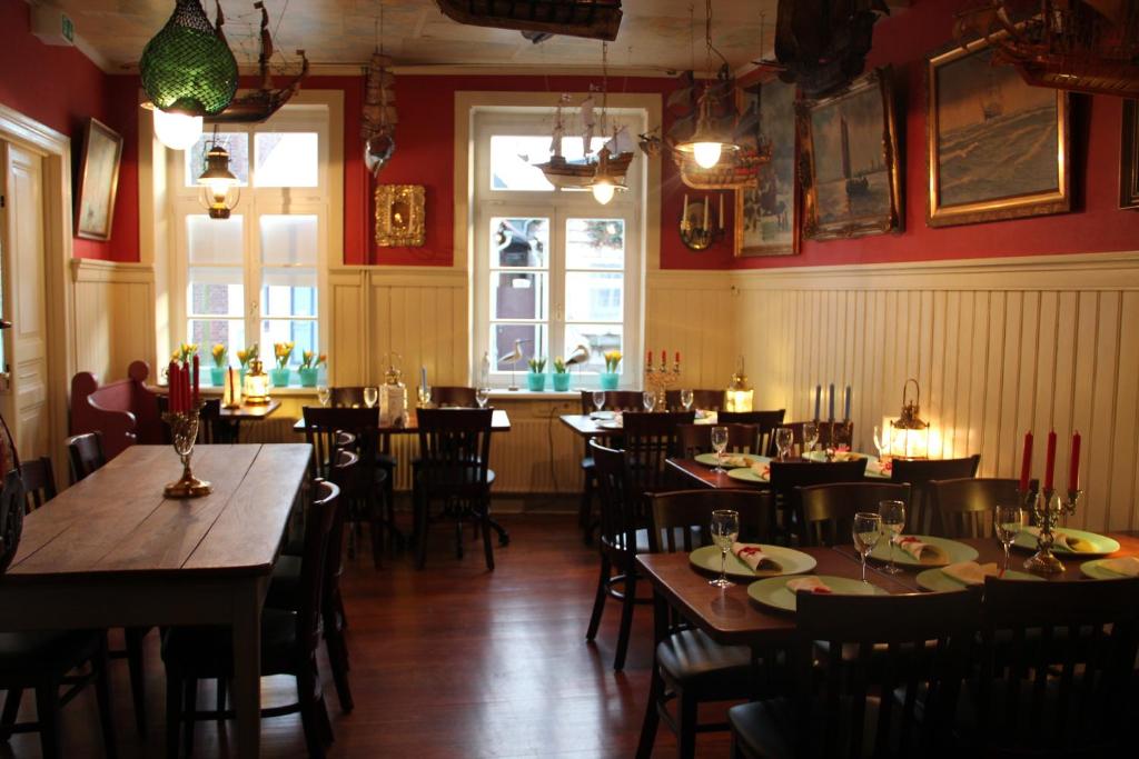 um restaurante com mesas e cadeiras de madeira numa sala em Hotel Lili Marleen em Travemünde