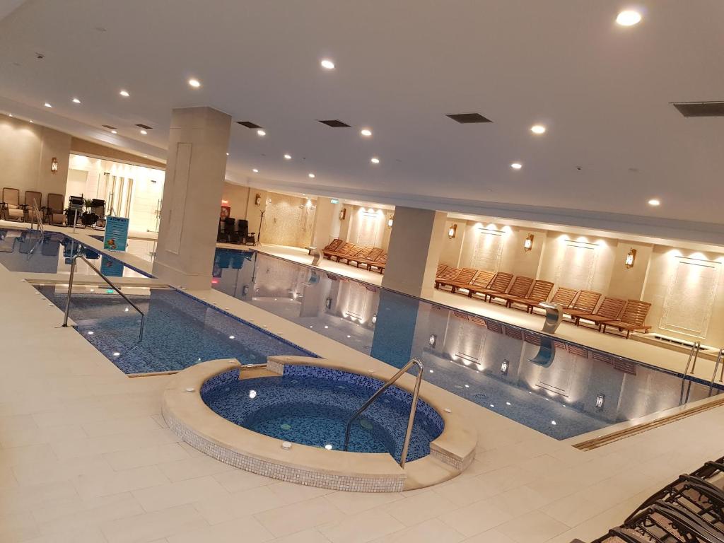 a large swimming pool in a large building at Grand Hotel Minerva Resort & SPA in Băile Herculane