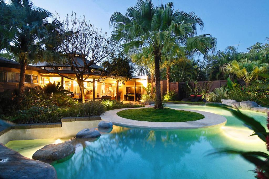 a house with a swimming pool in front of a house at Villa Don Vito in Tamarindo