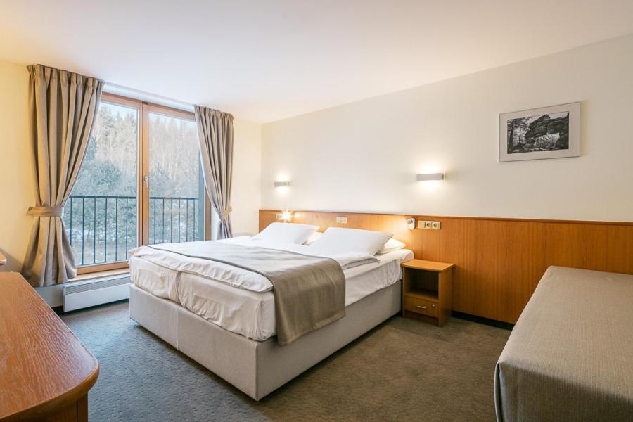 a hotel room with a bed and a window at Hotel Ostrov in Tisá