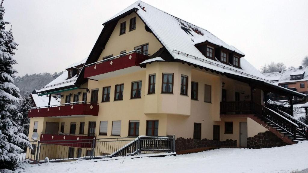 une grande maison avec de la neige sur le toit dans l'établissement Landgasthof Zum Hirschen, à Hafenlohr