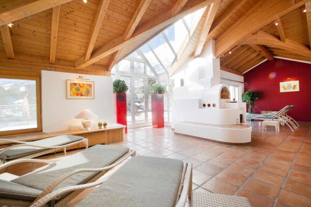 een grote kamer met stoelen en een open haard bij Hotel Schrofenstein in Landeck