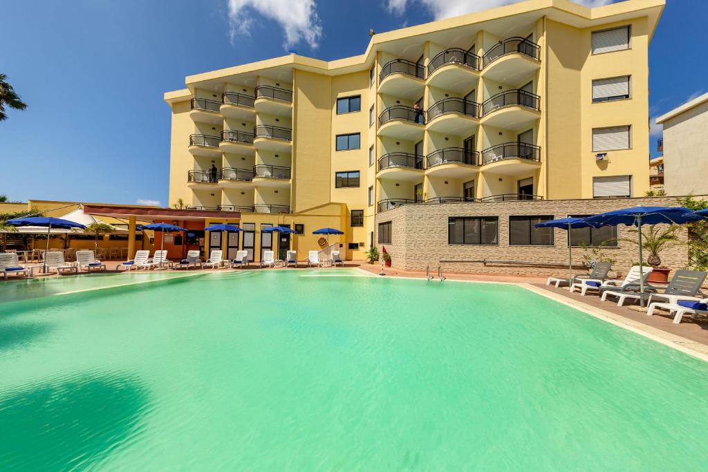 une grande piscine en face d'un hôtel dans l'établissement Rina Hotel, à Alghero