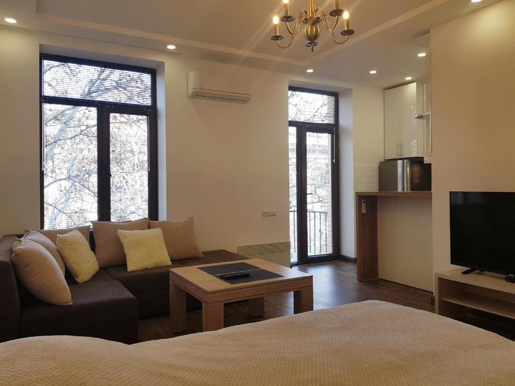a living room with a couch and a tv at Cascade White Luxury Apartment in Yerevan
