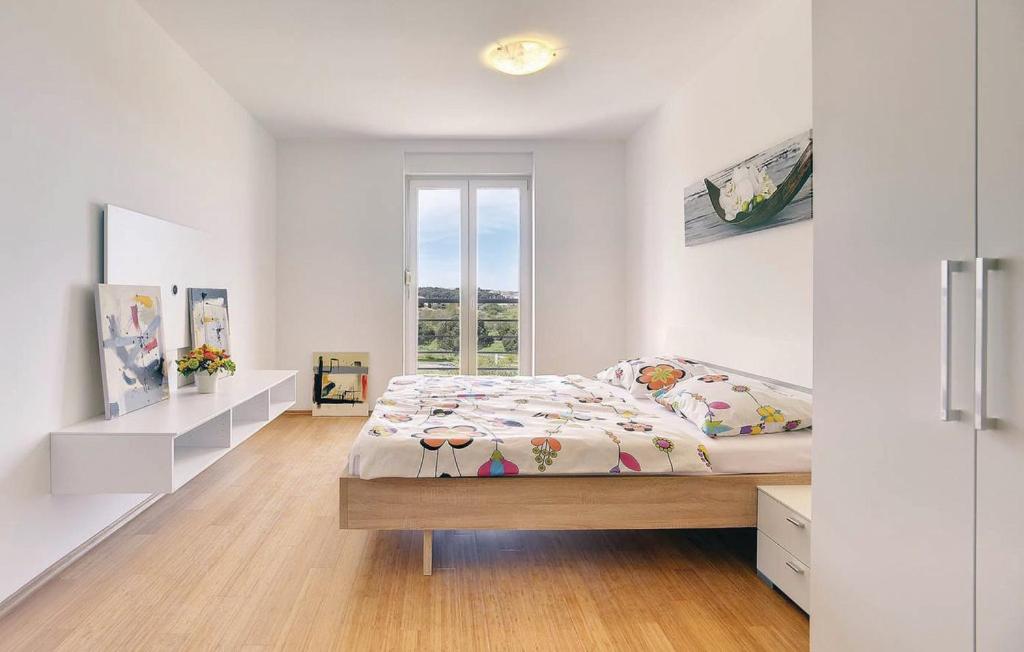 a white bedroom with a bed and a window at Apartments Vea in Pula