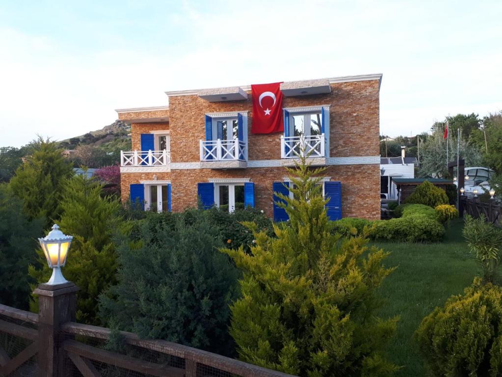 een huis met een rode vlag in het raam bij Aliş Boutique Hotel in Canakkale
