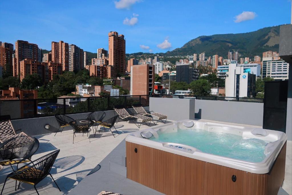 uma banheira de hidromassagem no último piso com vista para a cidade em Hotel Dix em Medellín
