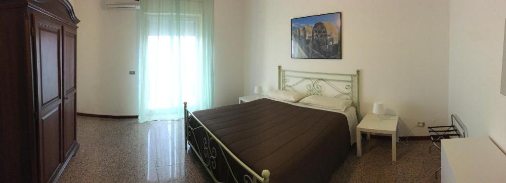 1 dormitorio con cama, mesa y ventana en A casa di Anastasia en Motta SantʼAnastasia