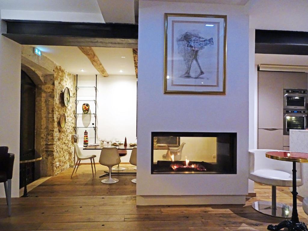 sala de estar con chimenea y mesa en Demeure d'hôtes Le Rocher, en Valbonne