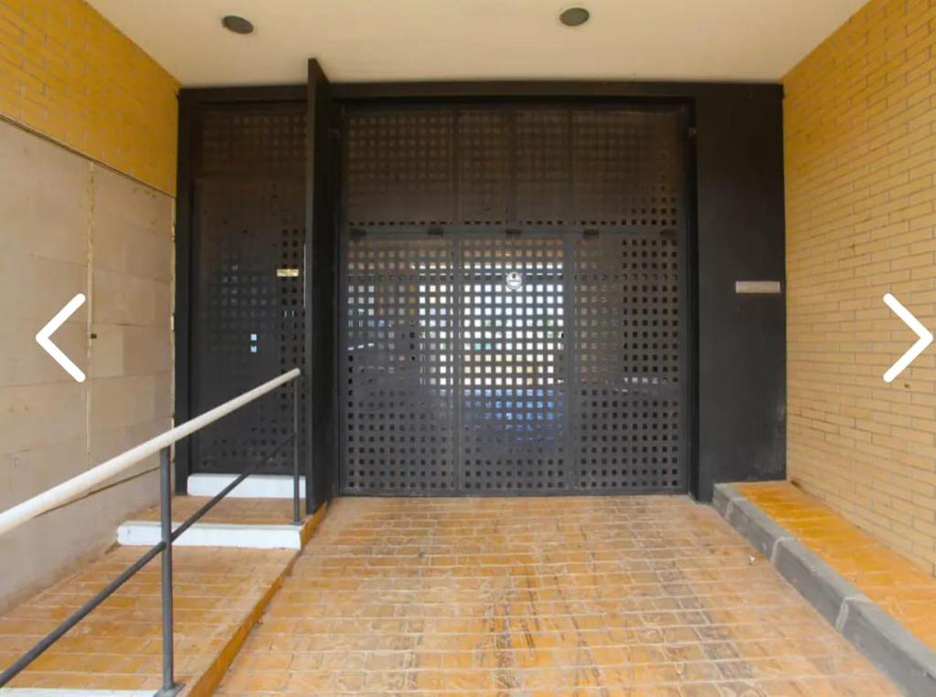 uma grande porta de metal num edifício com uma parede de tijolos em El Nostre em Deltebre
