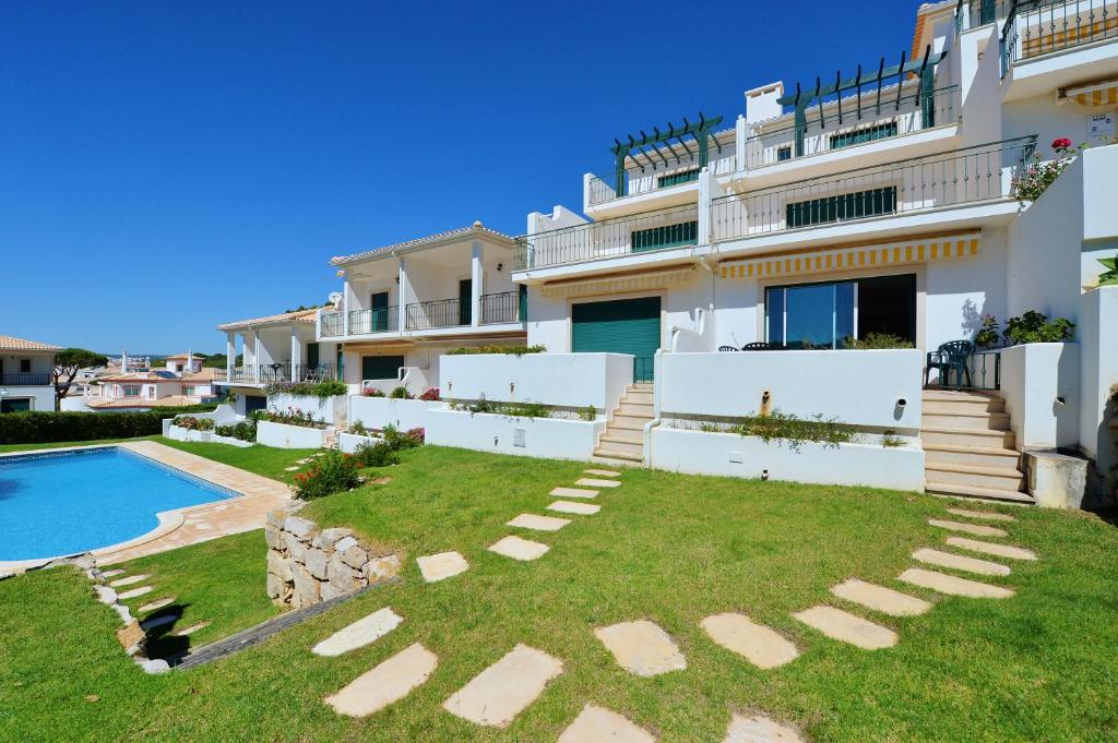ein großes Haus mit Garten und Pool in der Unterkunft TownHouse next to Falésia Beach in Albufeira