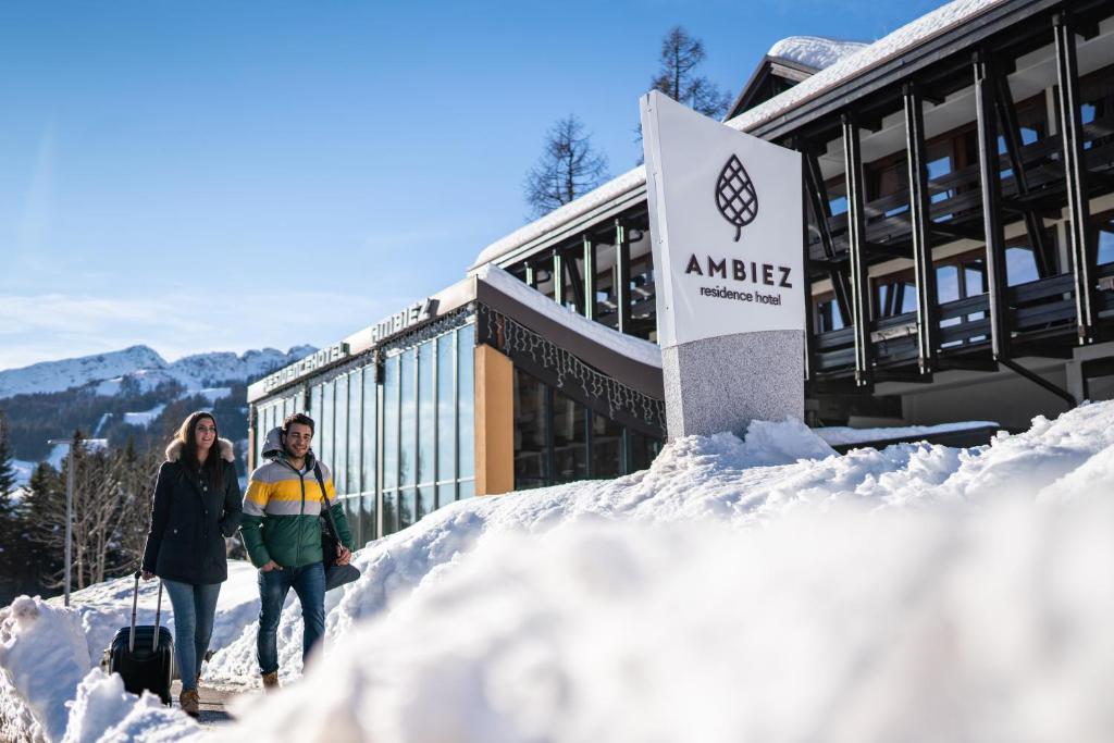 a woman standing in front of a snow covered ski slope at Ambiez Residencehotel in Madonna di Campiglio
