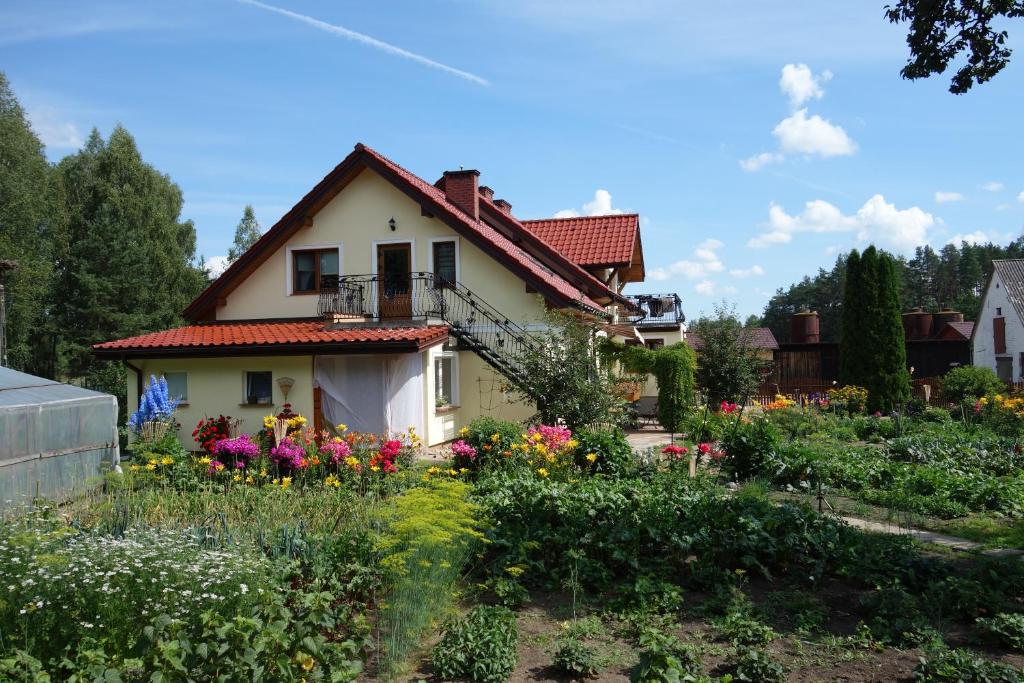 a garden in front of a house with flowers at Gospodarstwo Agroturystyczne Kamez in Szczytno