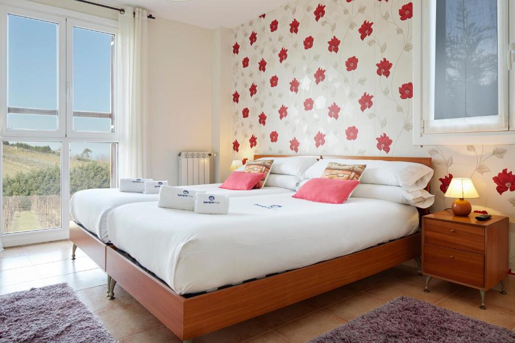 a bedroom with a large bed with pink pillows at Casa Rural Xabin Etxea - Basque Stay - XSS00041 in Getaria