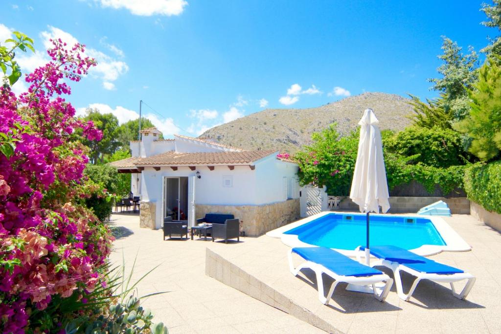 a villa with a swimming pool and a house at Beach Villa Carmen in Playa de Muro