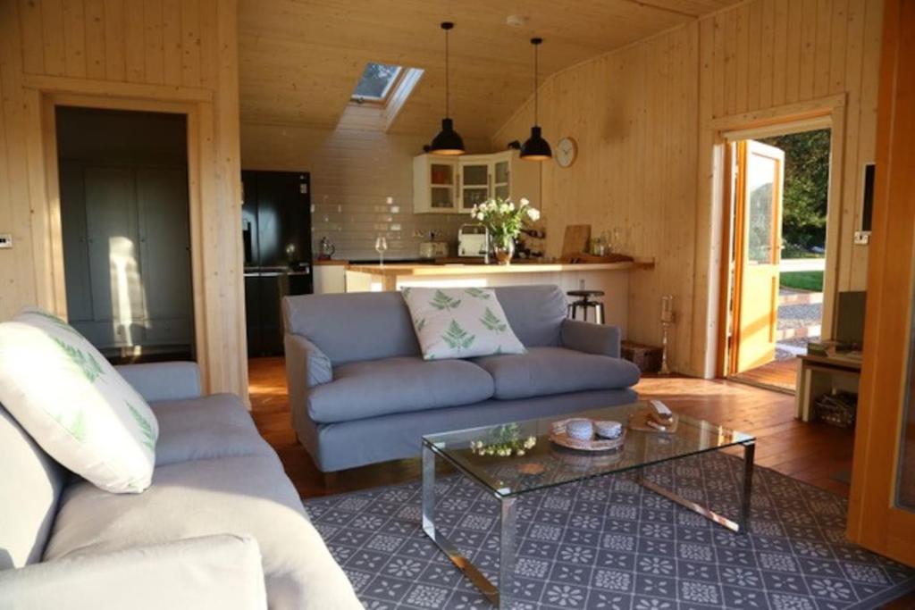 a living room with a couch and a table at Honeysuckle in Hadleigh