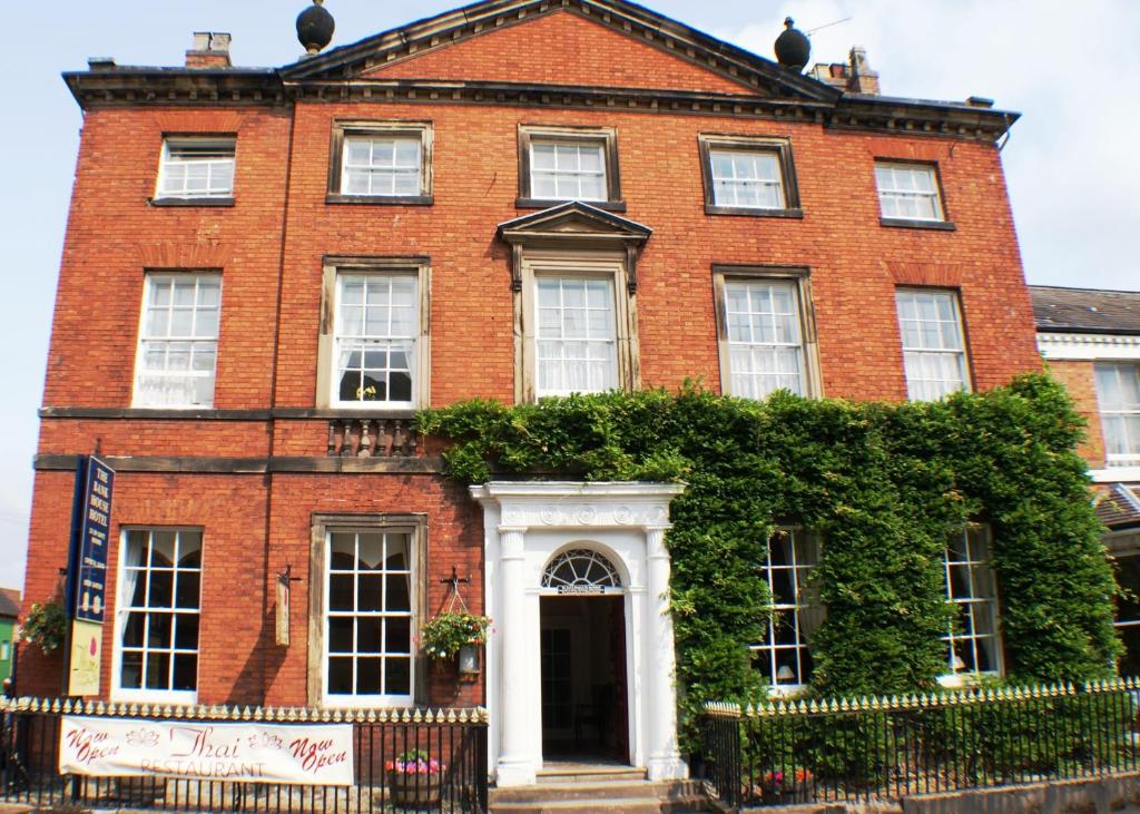 um edifício de tijolos vermelhos com uma porta branca em The Bank House Hotel em Uttoxeter