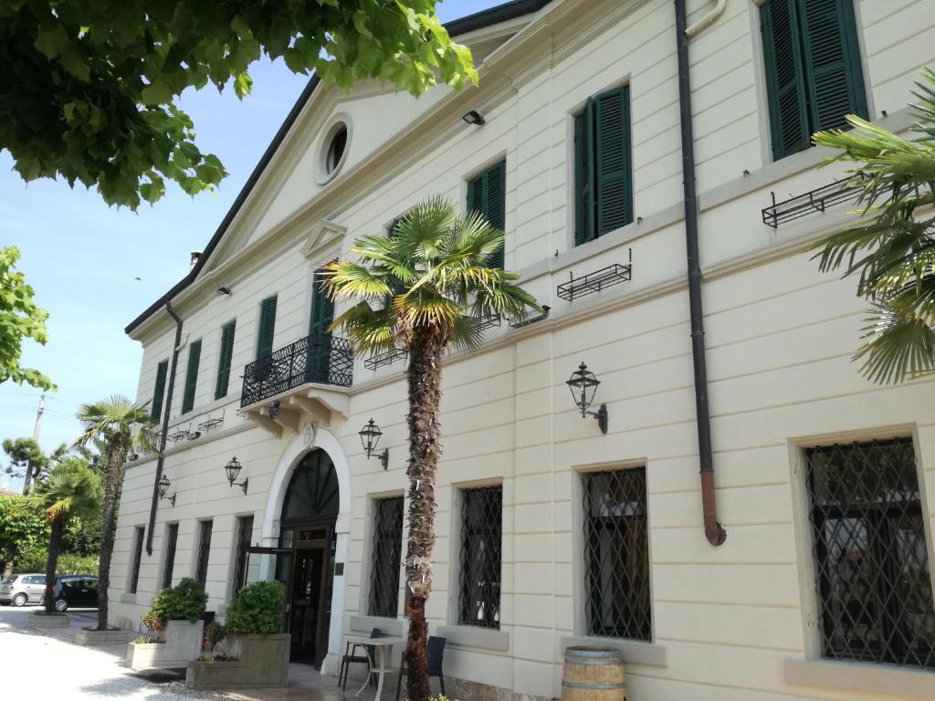a building with a palm tree in front of it at Hotel Dogana in Sirmione