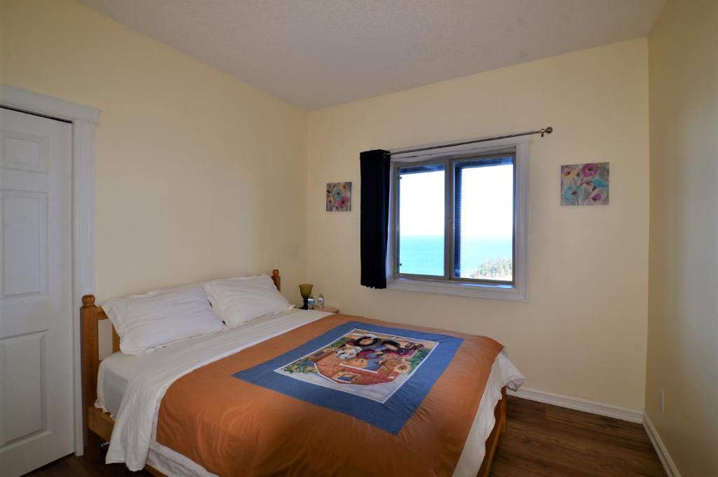 a bedroom with a bed and a window at Gibralter Rock Ocean View B&B in Nanaimo