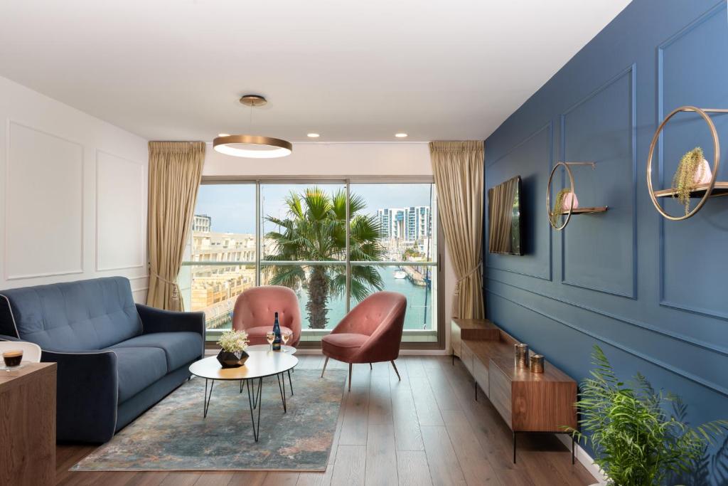 a living room with blue walls and a blue couch at Herzliya Marina Lagoon Apartment in Herzliyya B