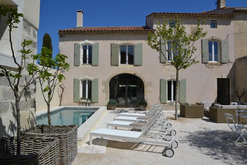 a house with a swimming pool and lounge chairs at Mas À l'Improviste in Saint-Rémy-de-Provence