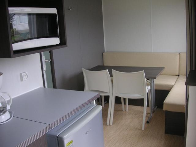 a room with a table and chairs and a tv at Camping la Croix du Sud in Saint-Tropez