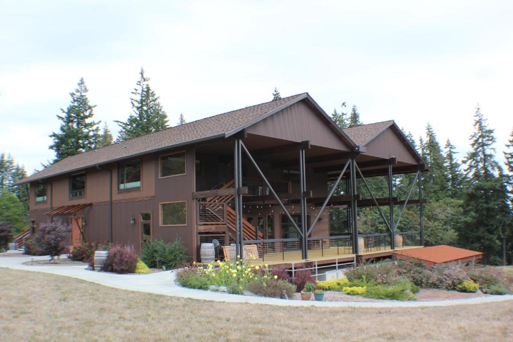 Casa grande de color marrón con porche grande y patio en Comforts of Whidbey, en Langley